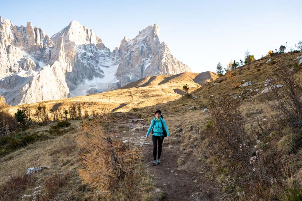 A female hiker walking along the path to Monte Castellaz with Cimon Della Palla in the background